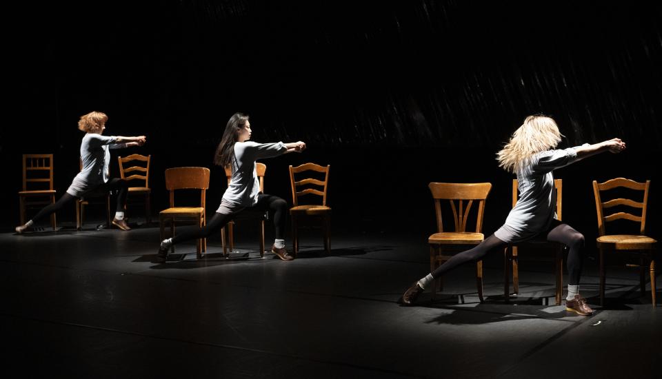 3 danseuses visibles dansant sur des chaises en bois